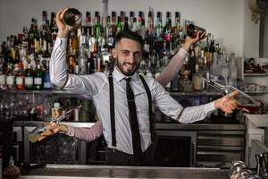 Bartenders with shakers and bottles in pub photo