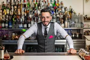 barman positivo parado en el mostrador foto