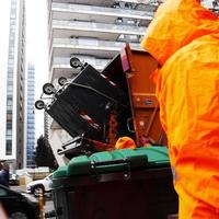 imagen borrosa de movimiento de un trabajador del servicio de limpieza vaciando el cubo de basura. foto