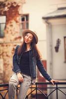 stylish model sitting on the railing in the city photo