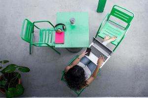 Unrecognizable freelancer with smartphone and laptop on terrace photo