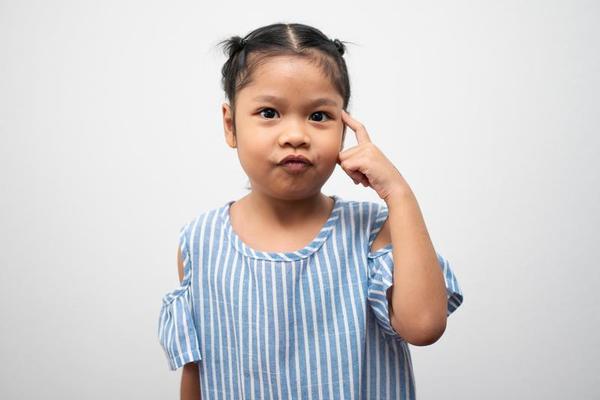 Portrait of Asian child 5 year old and to collect hair and Put your index finger to the head and make thinking pose on isolated white background, She is Happiness, radiance in Portrait of Asian child 5 year old and to collect hair and Put your index finger to the head and make thinking pose on isolated white background, She is Happiness, radiance in