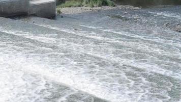 Close up, a waterfall flows from a river dam. video