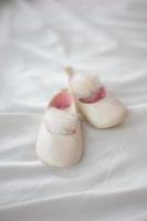 The first pair of children's sandals on a white fabric background. photo