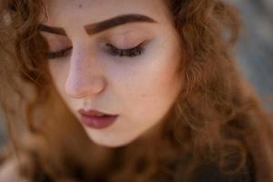 Autumn portrait of a red-haired girl on the street photo