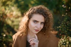 hermosa mujer elegante de pie en un parque en otoño foto