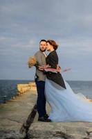 Wedding photo session of a couple on the seashore. Blue wedding dress on the bride.