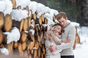 una pareja enamorada se calienta y se abraza. boda de invierno. el novio besó tiernamente a su novia en la sien foto