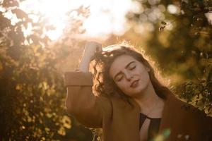 Beautiful elegant woman standing in a park in autumn photo