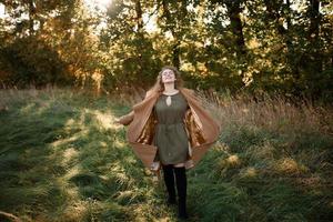 Beautiful elegant woman standing in a park in autumn photo