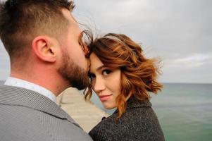 Wedding photo session of a couple on the seashore. Blue wedding dress on the bride.