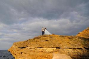 Wedding photo session of a couple on the seashore. Blue wedding dress on the bride.
