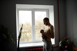 A father holds in his arms his newborn son. photo