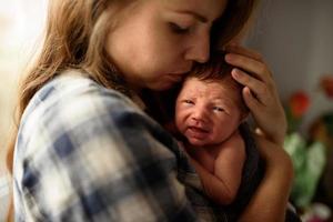 Mom holds in her arms her newborn son. photo