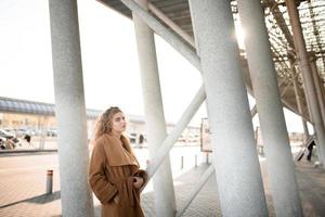 Close-up Fashion woman portrait of young pretty trendy girl posing at the city in Europe,summer street fashion,holding retro fedora hat popular until the 60s.laughing and smiling portrait.trendy photo