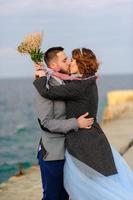 sesión de fotos de boda de una pareja a la orilla del mar. vestido de novia azul en la novia.