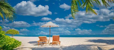 Tranquil beach scene, couple chairs, umbrella. Exotic tropical beach landscape destination for background or wallpaper. Design of romantic summer vacation holiday concept. photo