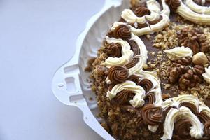 Black cake with nuts on a backing photo
