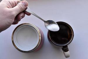 Sugar bowl with a spoon and a mug of tea photo