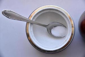 Sugar bowl with a spoon and a mug of tea photo