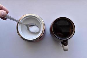 Sugar bowl with a spoon and a mug of tea photo