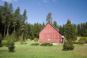 Red barn on a small hill side. photo