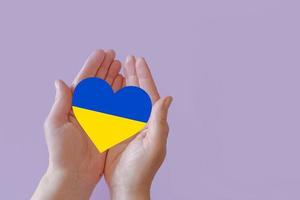 love blue and yellow heart in hands on colorful background.  Ukraine concept photo