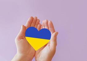 love blue and yellow heart in hands on colorful background.  Ukraine concept photo