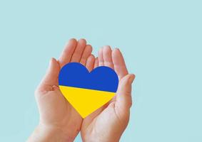 love blue and yellow heart in hands on colorful background.  Ukraine concept