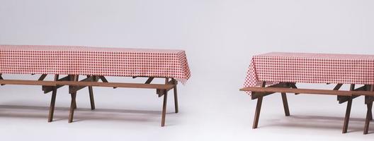 Picnic table and red checkered tablecloth with food and drink for outdoor party. Isolated photo