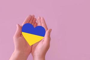 love blue and yellow heart in hands on colorful background.  Ukraine concept