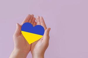 love blue and yellow heart in hands on colorful background.  Ukraine concept photo