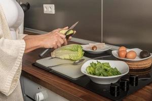 Crop woman cutting vegetables for salad photo