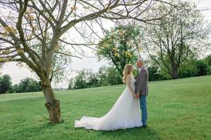 The bride and groom hold each other's hands. A man and a woman look into each other's eyes. photo