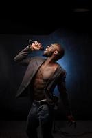 A black African American is emotionally singing into a microphone. Close-up studio portrait. photo