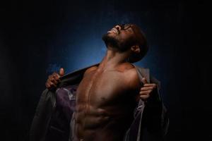 A black African American is emotionally singing into a microphone. Close-up studio portrait. photo