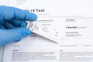 resultado positivo de la prueba mediante el uso de un dispositivo de prueba rápida para covid-19. foto