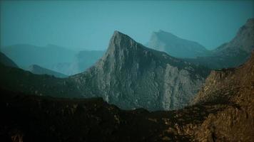 silhouette of swiss alps mountains in morning clouds photo