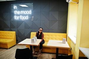 en el estado de ánimo para la comida. mujer africana en café. foto