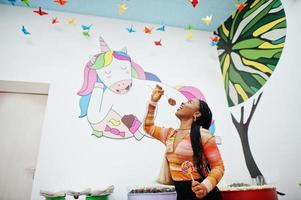 African american millennial lady at candy shop with lolipops. photo