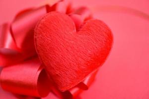 corazón sobre fondo rojo para la filantropía - corazón rojo día de san valentín o donar ayuda dar amor calidez cuidar el concepto foto