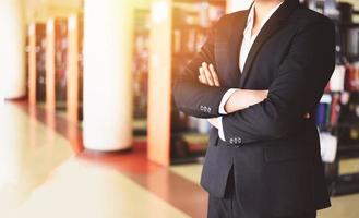 businessman standing in a office - smart business man or student standing in the library room with bookshelf background education concept photo