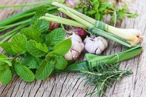 concepto de jardín de hierbas de cocina - hierbas frescas naturales y especias sobre fondo de madera rústica en la cocina para alimentos de ingredientes foto