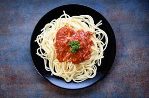 Spaghetti italian pasta served on black plate with tomato sauce and parsley in the restaurant italian food and menu concept spaghetti bolognese photo