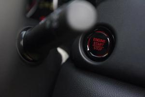 parada de arranque del motor con luz roja en un botón de parada de arranque del motor de coche de nueva tecnología - foto