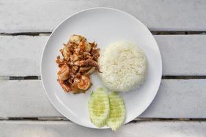 Garlic Fried Seafood Fried shrimp squid fish with rice on white plate and cucumber photo