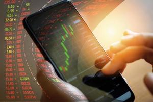 Gráfico de cotización o forex en línea con aplicación en smartphone: gráfico de cotización de empresario con análisis estadístico tabla de precios mercado financiero en datos y tecnología de finanzas de teléfono móvil foto