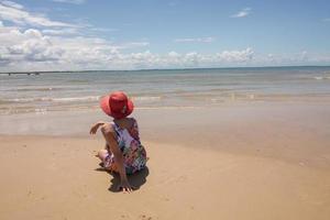 Lady enjoying herself on a sunny sitting on a lone stretch of Beach in Corumbau, Bahia, Brazil photo