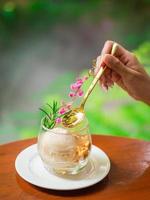 Female hand holding a golden spoon with tasty ice cream on wooden table. photo