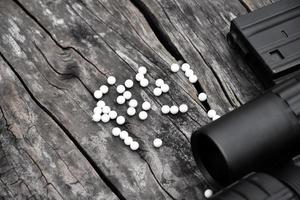 Closeup of white plastic bullets of airsoft gun or bb gun on wooden floor, soft and selective focus on white bullets. photo